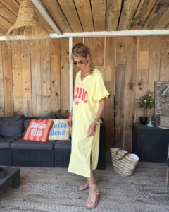 Robe tee-shirt jaune Iconic en coton avec inscription rose portée par Lucie
